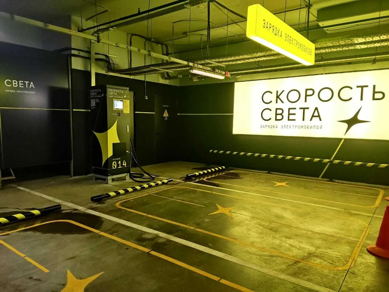 Зона зарядки с фирменным световым коробом «Скорость Света» на паркинге ТЦ